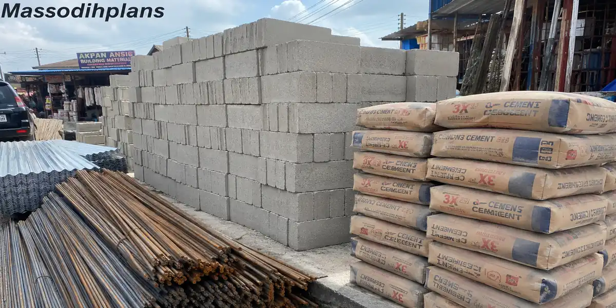 Stacked sandcrete blocks, bags of cement, iron rods and corrugated roofing sheets at a Uyo building materials market