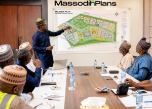 Registered Nigerian town planner presenting master plan map to community leaders and government officials in a planning meeting